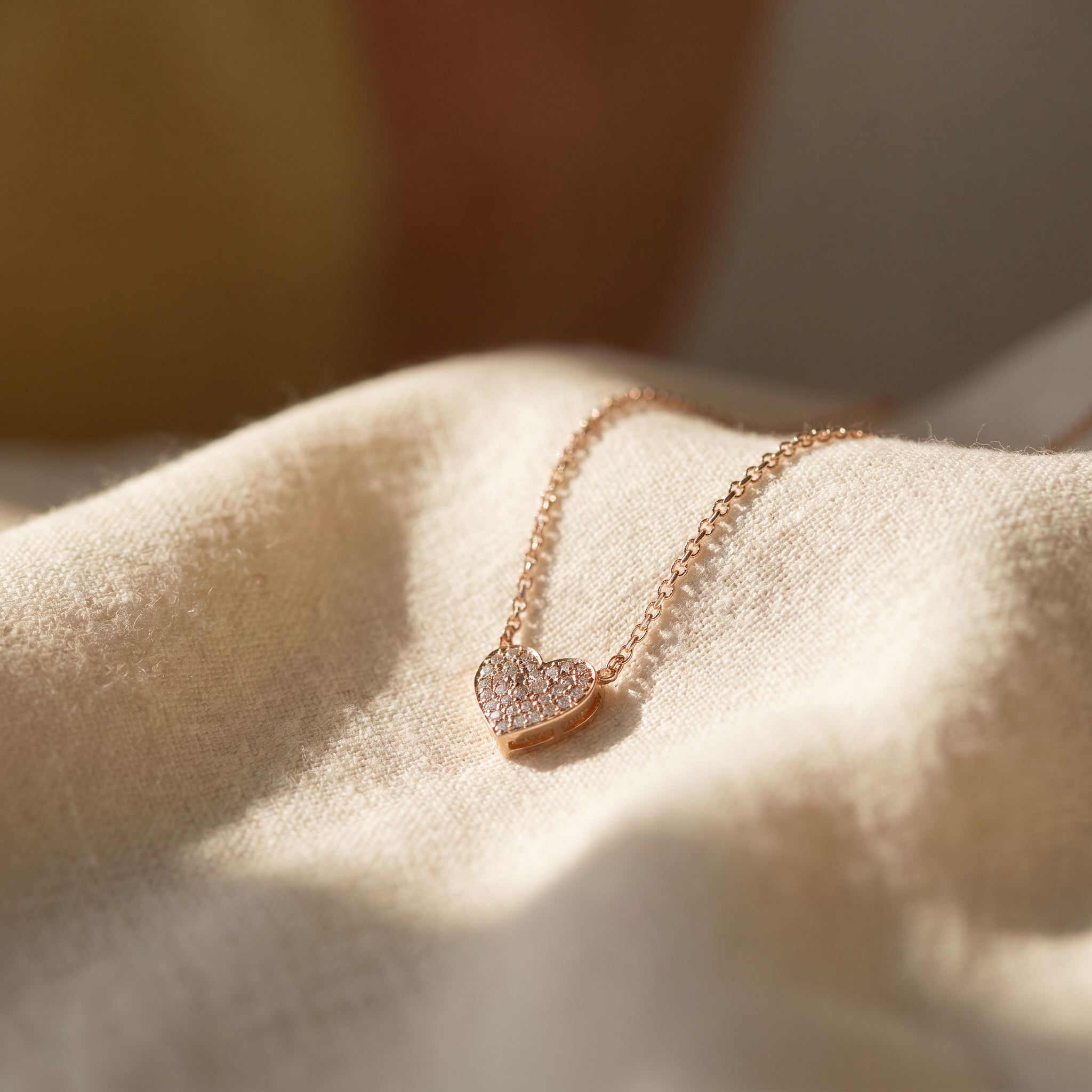 Diamond pavé heart pendant necklace in 18K rose gold on warm linen — the Necklaces collection