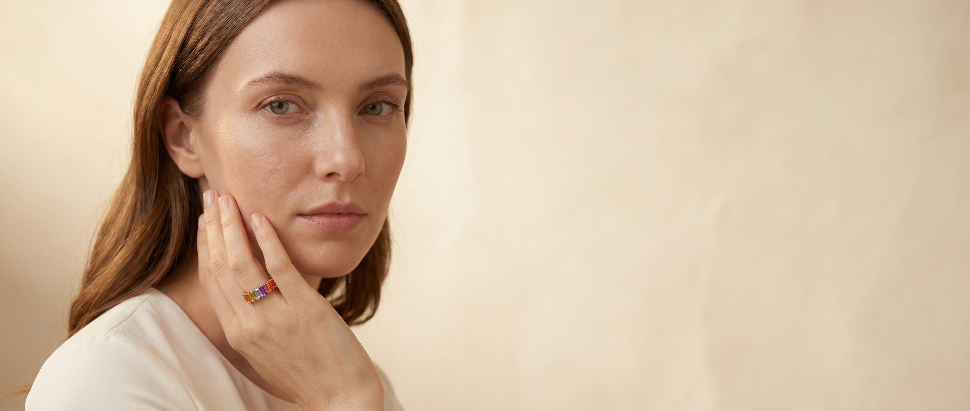 A woman wearing a rainbow sapphire ring