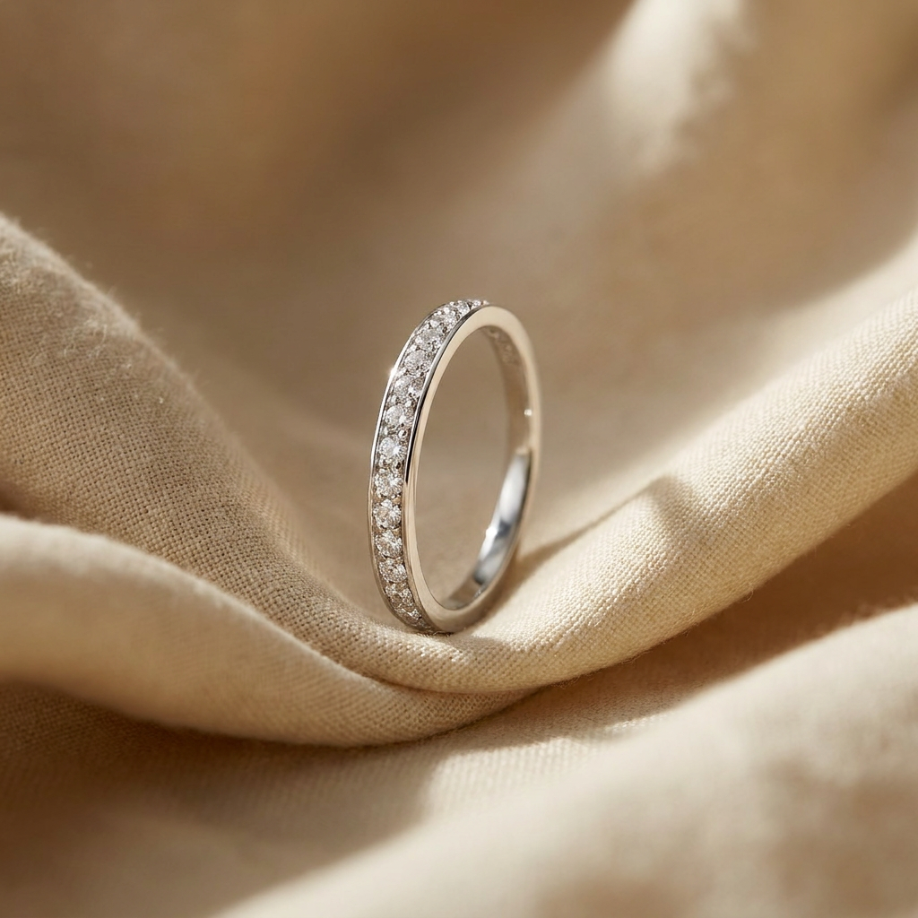 Diamond eternity band in 18K white gold, editorial scene on warm linen