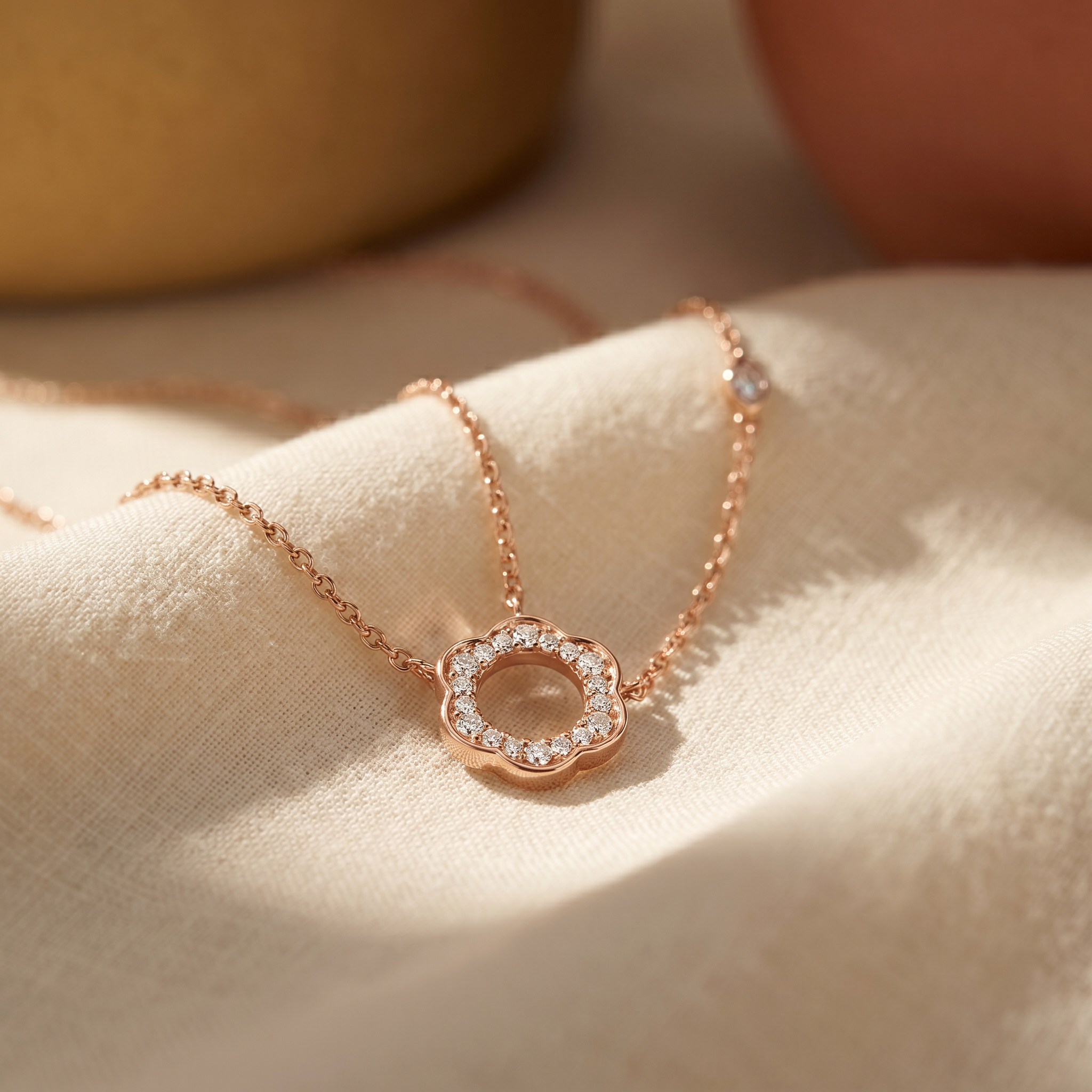 Diamond floral circle pendant necklace in 18K rose gold, editorial scene on warm linen